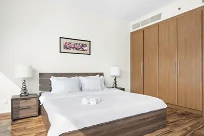 a bedroom with a large bed with two white towels at VayK - Spacious 2BR in JLT with Marina Views in Dubai