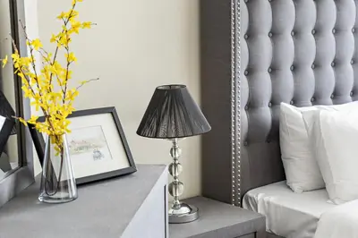 a bedroom with a bed and a table with a lamp at VayK - Spacious 2BR in JLT with Marina Views in Dubai