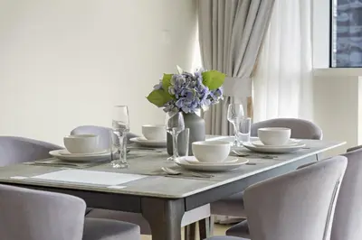a dining room table with a vase of flowers on it at VayK - Spacious 2BR in JLT with Marina Views in Dubai