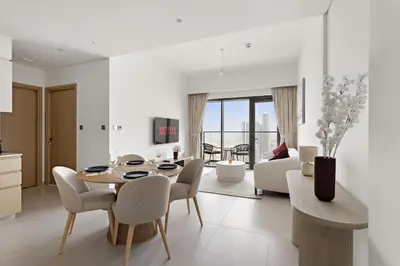 a kitchen and living room with a table and chairs at VayK - Stylish 1BR in Prime Downtown Location in Dubai