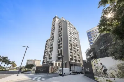 a tall building with a van parked in front of it at VayK - Brand New 1BR in Dubai Hills in Dubai