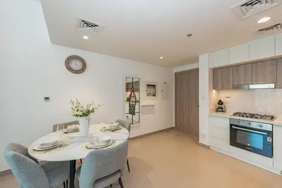 a kitchen and dining room with a table and chairs at VayK - Brand New 1BR in Dubai Hills in Dubai