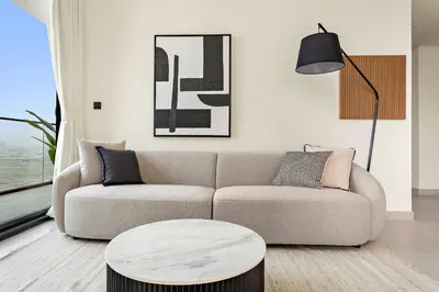 a living room with a couch and a table at VayK - Stylish 2BR in JVC with Private Pool in Dubai
