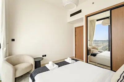 a hotel room with a bed and a chair at VayK - Stylish 2BR in JVC with Private Pool in Dubai