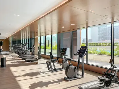 a gym with rows of treadmills and elliptical machines at VayK - Stylish 2BR in JVC with Private Pool in Dubai
