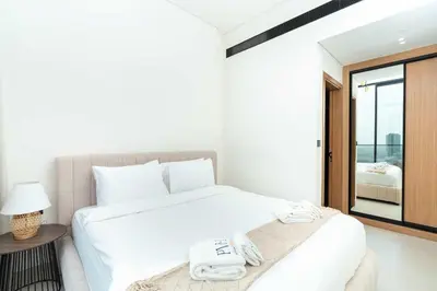 a bedroom with a large white bed and a mirror at PVH - Serene 1BR with City View - Binghatti House in Dubai