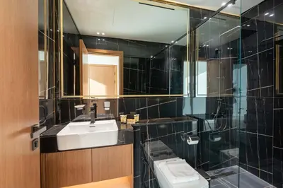 a black tiled bathroom with a sink and a toilet at PVH - Serene 1BR with City View - Binghatti House in Dubai