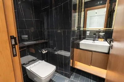 a bathroom with a toilet and a sink and a mirror at PVH - Cozy 1BR with City View - Binghatti House in Dubai