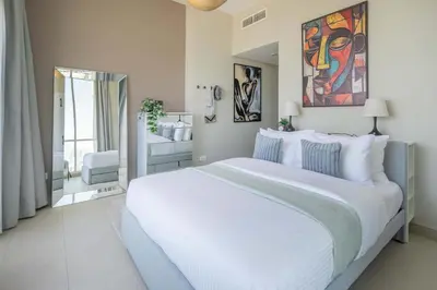 a bedroom with a large white bed and a bathroom at Frank Porter - Hilliana Tower in Dubai