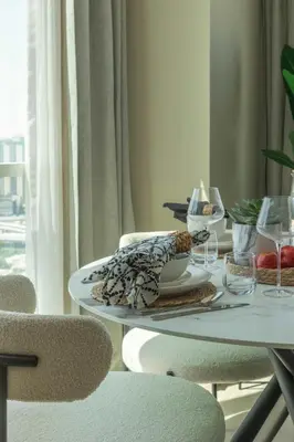 a table with a plate of food and wine glasses at Frank Porter - Hilliana Tower in Dubai
