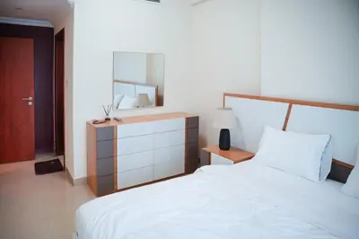 a bedroom with a bed and a dresser with a mirror at 1 Bedroom Apartment at Marina with Stunning View in Dubai
