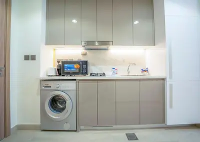 a kitchen with a washing machine and a sink at AWS Holiday Homes - Comfy Cozy Studio in Dubai