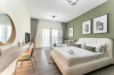 a bedroom with a large white bed and a couch at HAVN - Studio in Alka, The Greens in Dubai