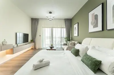 a living room with a white couch and a tv at HAVN - Studio in Alka, The Greens in Dubai