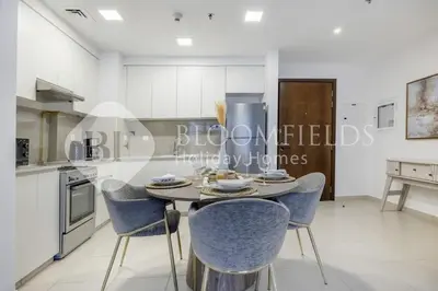 a dining room with a table and chairs in a kitchen at Bloomfields Cozy 1br Apt Town Square in Dubai