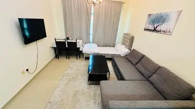 a living room with a couch and a table at Beautiful 1 Bedroom Apartment close to metro in Dubai