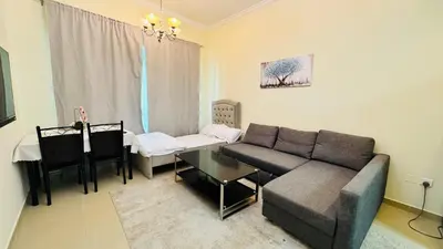a living room with a couch and a table at Beautiful 1 Bedroom Apartment close to metro in Dubai