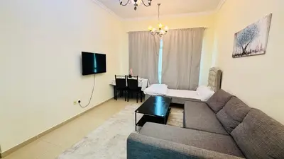 a living room with a couch and a table at Beautiful 1 Bedroom Apartment close to metro in Dubai