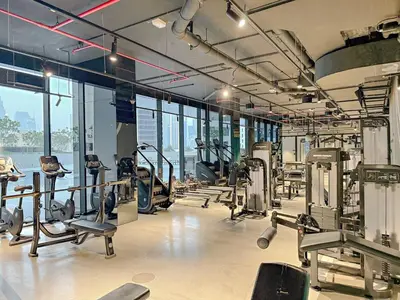 a gym with a lot of treadmills and machines at FIRST CLASS Studio Marquise Bliss in Dubai