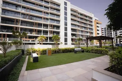 a park in front of a large building at Azizi Riviera Modern Studio Near Downtown in Dubai