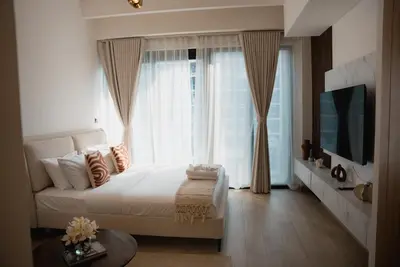 a bedroom with a bed and a large window at Azizi Riviera Modern Studio Near Downtown in Dubai