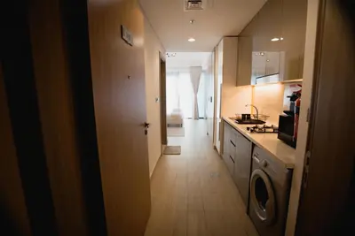 a hallway of a kitchen with a washer and dryer at Azizi Riviera Modern Studio Near Downtown in Dubai