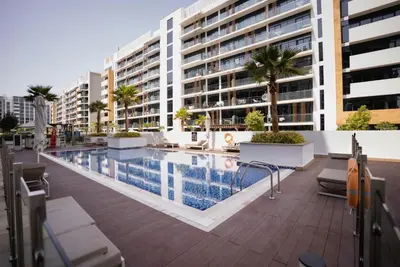 a swimming pool in front of a building at Azizi Riviera Modern Studio Near Downtown in Dubai