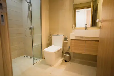 a bathroom with a toilet and a shower and a sink at Azizi Riviera Modern Studio Near Downtown in Dubai