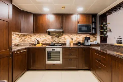 a large kitchen with wooden cabinets and appliances at Comfortable - Vibrant - Convenient in Dubai