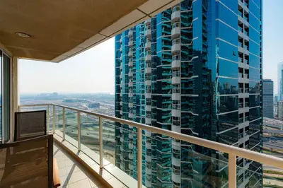 a balcony with a view of a tall blue building at Comfortable - Vibrant - Convenient in Dubai