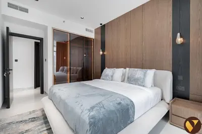 a bedroom with a large white bed and wooden walls at Vogue Marina Dorra Bay near JBR Beach and Ain Dubai, Two Bedroom apartment with Balcony, Canal and Skyline View, Access to all Amenities in Dubai
