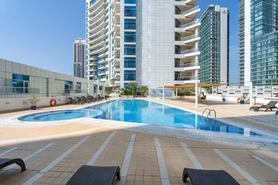 a large swimming pool in a city with tall buildings at Vogue Marina Dorra Bay near JBR Beach and Ain Dubai, Two Bedroom apartment with Balcony, Canal and Skyline View, Access to all Amenities in Dubai