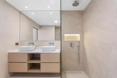 a bathroom with two sinks and a shower at Cozy 3 Bedroom with walking access to JBR Beach in Dubai