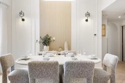 a white dining room with a white table and chairs at Cozy 3 Bedroom with walking access to JBR Beach in Dubai