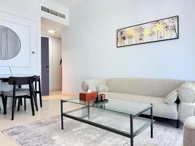 a living room with a couch and a table at Mahenti - Spacious 1-Bedroom Apartment in JVC in Dubai