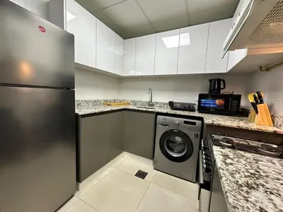 a kitchen with a washer and dryer in a kitchen at Mahenti - Spacious 1-Bedroom Apartment in JVC in Dubai