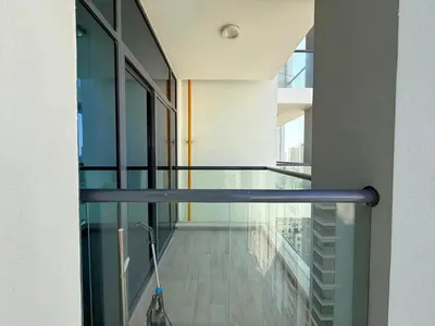 a vacuum cleaner is on a glass balcony at Mahenti - Spacious 1-Bedroom Apartment in JVC in Dubai