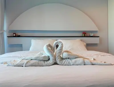 two towel swans sitting on top of a bed at Mahenti - Spacious 1-Bedroom Apartment in JVC in Dubai
