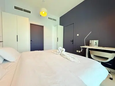 a large white bed with a stuffed animal on it at Mahenti - Spacious 1-Bedroom Apartment in JVC in Dubai