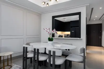 a dining room with a white table and chairs at Luxury 1st Row Burj Khalifa and Fountain Views, Walk to Dubai Mall in Dubai