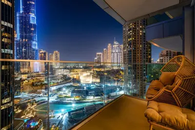 a room with a view of a city at night at Luxury 1st Row Burj Khalifa and Fountain Views, Walk to Dubai Mall in Dubai