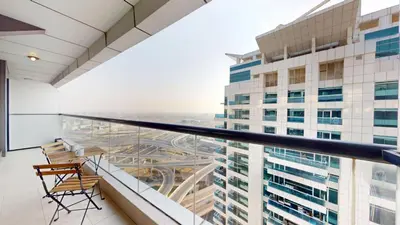 a balcony with chairs and a view of a building at Locations l Upgraded 1 Bedroom l Marina Views l Free Pool Access in Dubai