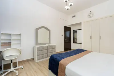 a bedroom with a bed and a chair and a mirror at CitiHome - Modern & Stylish 1BR in Dubai Marina in Dubai