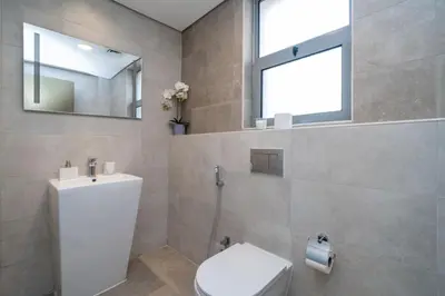 a bathroom with a toilet and a sink and a window at Elegant JVC 1-Bed with Upgraded Interiors in Dubai