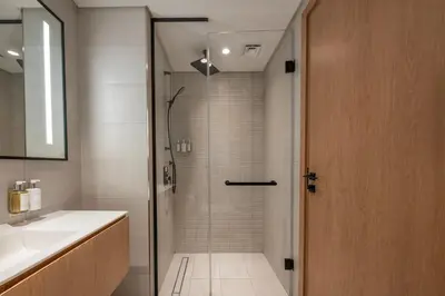 a shower with a glass door in a bathroom at Luxury Studio at Marquise Square with Burj Khalifa View in Dubai