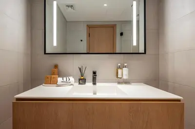 a bathroom with a white sink and a mirror at Luxury Studio at Marquise Square with Burj Khalifa View in Dubai