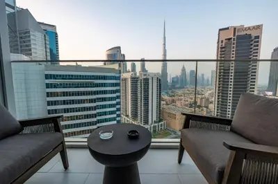 a room with two chairs and a table on a balcony at Luxury Studio at Marquise Square with Burj Khalifa View in Dubai