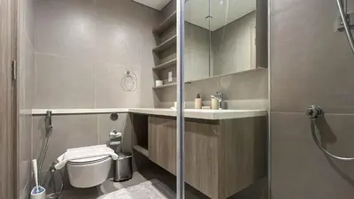 a bathroom with a shower and a toilet and a sink at Waterfront 1BR, Full Marina View & Pool Access - 34AB04 in Dubai