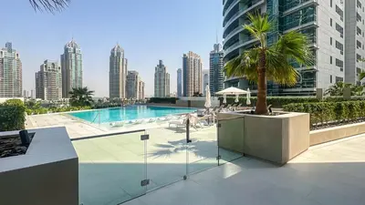 a swimming pool with a palm tree on top of a building at Waterfront 1BR, Full Marina View & Pool Access - 34AB04 in Dubai