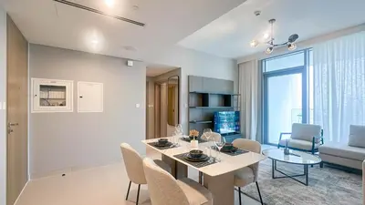 a dining room and living room with a table and chairs at Waterfront 1BR, Full Marina View & Pool Access - 34AB04 in Dubai